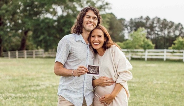 John Luke and his wife Mary Kate taking a picture with their baby worm ultrasound video photo.